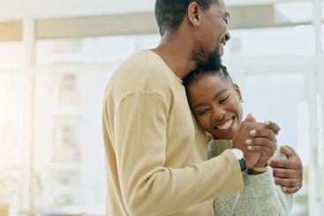 Black couple, dance and hug in home together with love,...