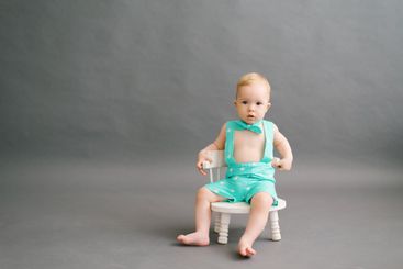 a one-year-old boy is sitting on a white children's...