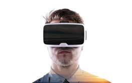 Double exposure. Man wearing virtual reality goggles. Sea at sunset.