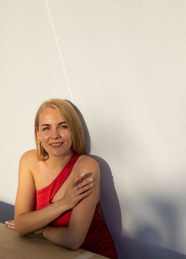 Beautiful blonde woman in red dress smiling with blue eyes