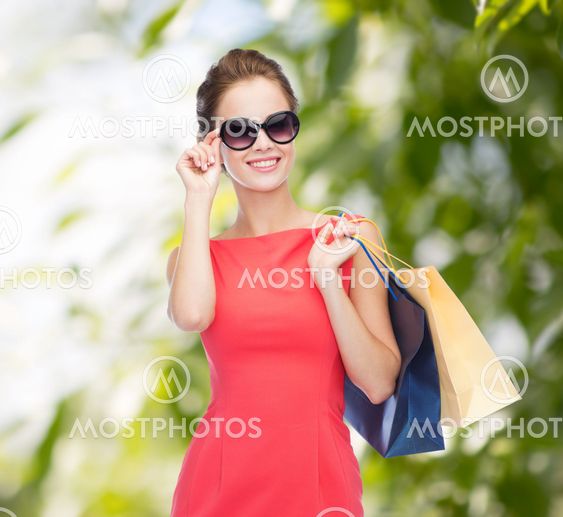 smiling elegant woman in dress with shopping bags