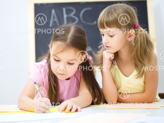 Little girls are writing using a pen