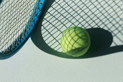 tennis racket and ball on the floor at room with daylight