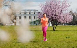 Sportive girl running in park on spring day