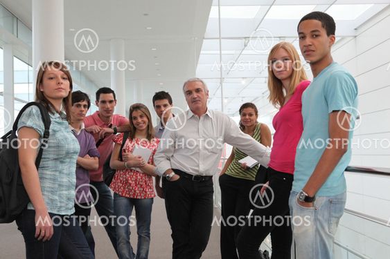 Group of students and teacher stood in corridor