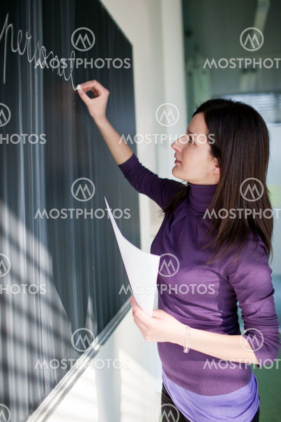portrait of a pretty college student working in a classroom