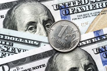 Close-up of 1 Russian rubles coin on US 100 dollar bills...