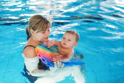 Little baby boy and his mother learning to swim in an...
