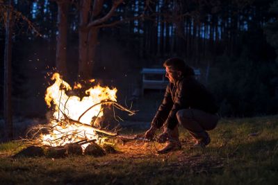 Man lights a fire in the fireplace in nature