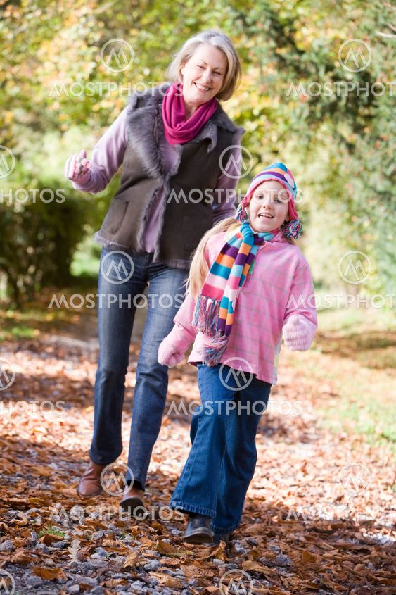 Grandmother and granddaughter playing in woods
