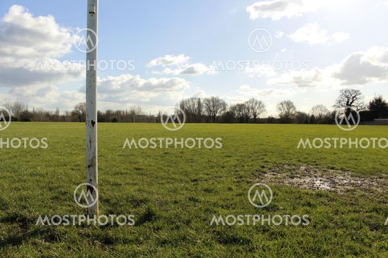 A Close Up Of A Goal Post On A Field In The Sun With Blue Sky And Clouds