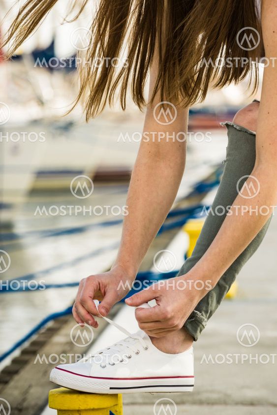 Woman tying laces in sneakers outdoors