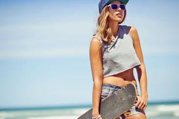 Thinking, travel and woman with skateboard by beach for...