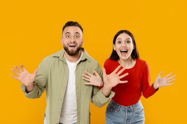 Young couple expressing excitement and joy against a...