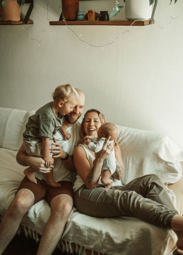 Bonding, family and parents with baby and toddler on a...