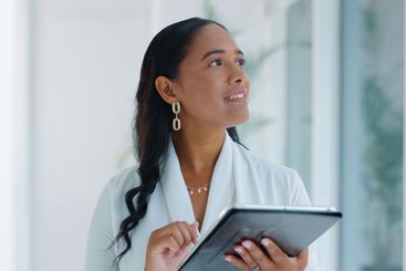 Business woman, tablet and reading in hallway at modern...