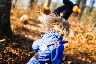 Lek med löv i skogen.