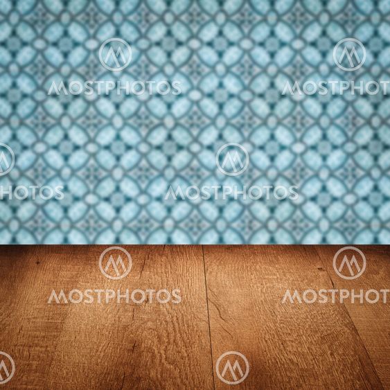 Wood table top and blur vintage ceramic tile pattern wall