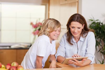 Woman and son using tablet in the kitchen