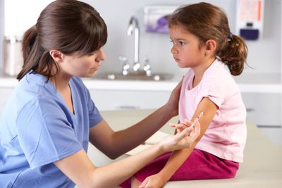 Doctor Giving Child Injection In Doctor's Office