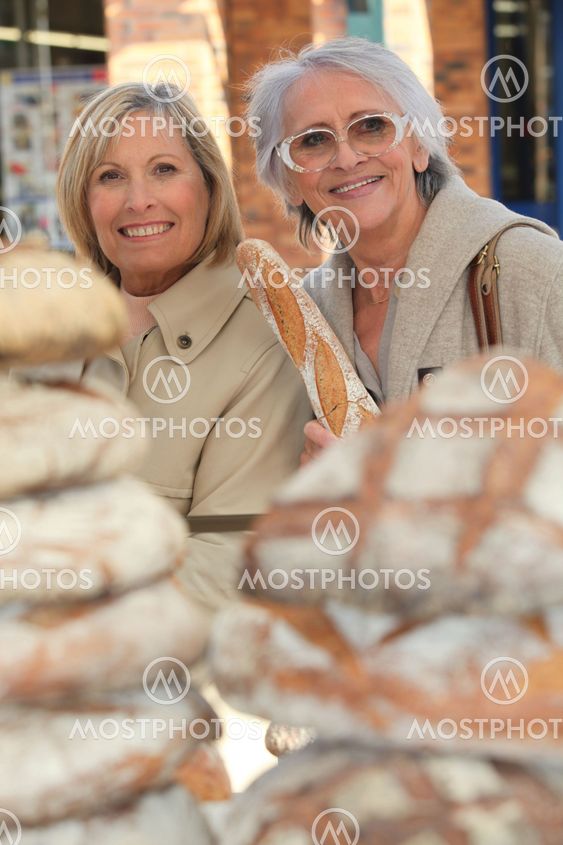 a 50 years old woman and a 70 years old woman in a bakery