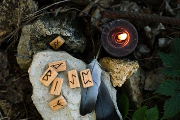 Top view of the stone altar where runes, feathers and...