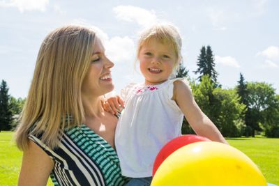 Mother And Daughter With Balloons In Park