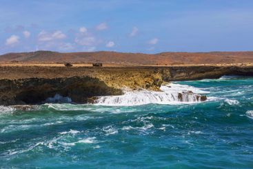 Waves crashing against rocky shore of Arikok National Park