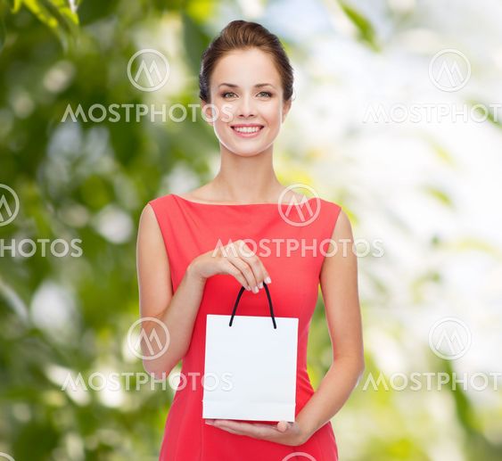 smiling elegant woman in dress with shopping bag