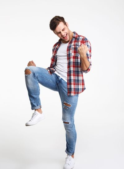 Full length portrait of a young satisfied man celebrating