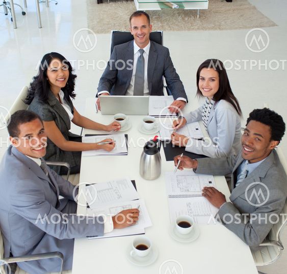 Business people in a meeting smiling at the camera