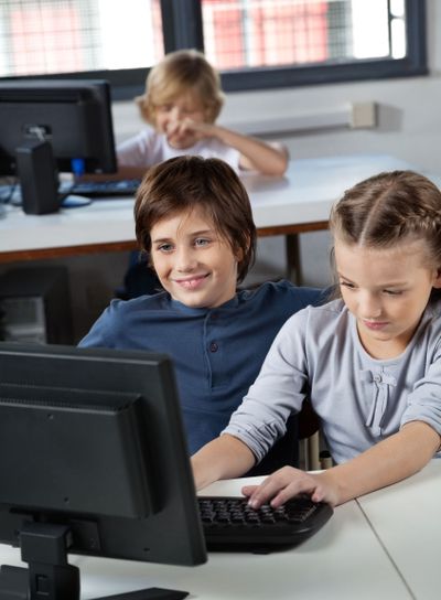 Little Boy And Girl Using Desktop Pc In Computer Lab