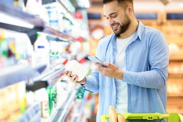 Man scanning code on products using smartphone