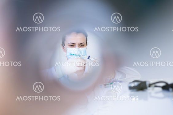 COVID-19 vaccine in researcher hands, female doctor...