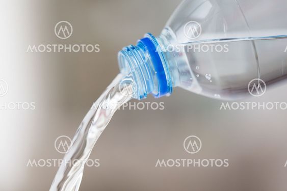 close up of water pouring from plastic bottle