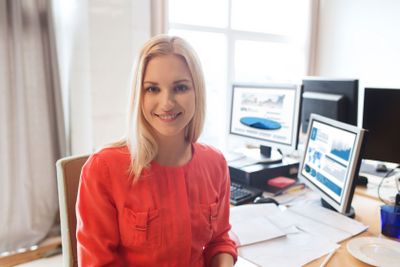 happy creative female office worker with computers