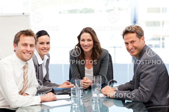 Portrait of a businesswoman with her team sitting at a table