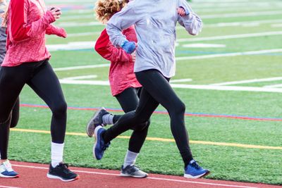 Four high school girls running on a track