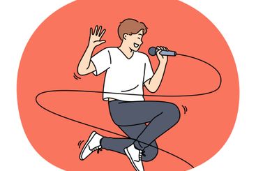 Jumping male singer with microphone enjoys performing...