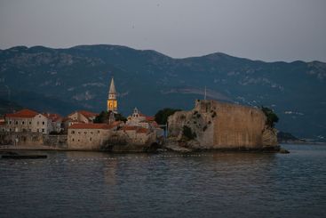 Coastal town at dusk with historic buildings and seaside...