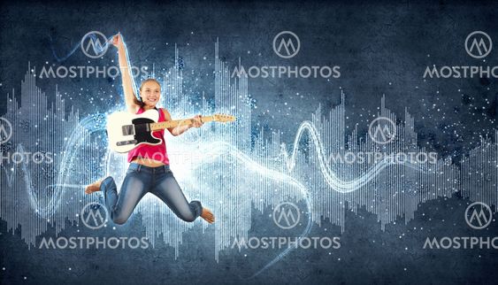 young woman playing on electro guitar and jumping