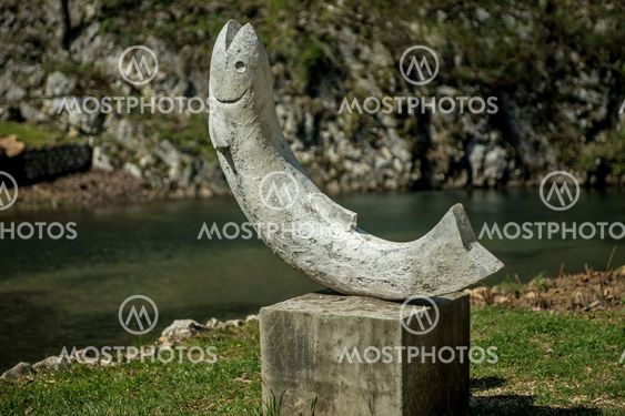 The statue in the shape of a fish on the river bank