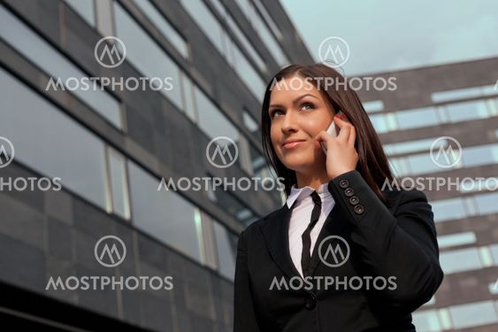 Smiling business woman on the phone at modern building