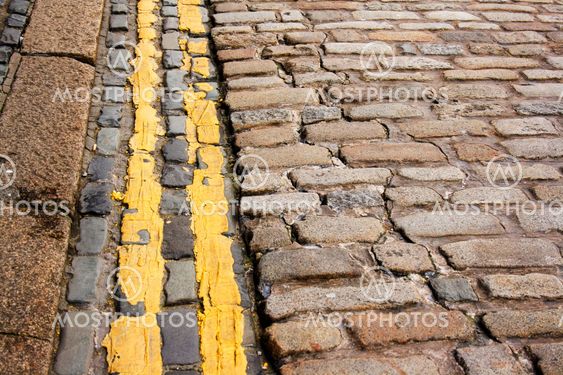 Modern (no parking) double yellow lines along ancient cobble stones