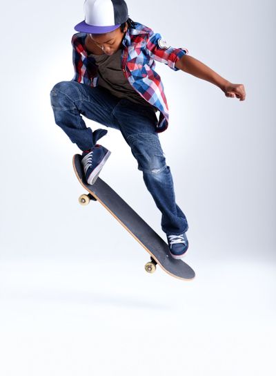 Skateboard trick, jump or African kid in studio with...