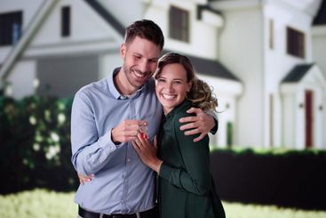 Portrait Of Happy Young Family Standing In Front