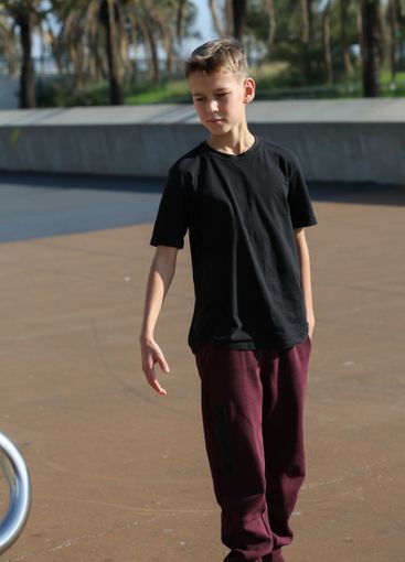 Handsome teenager standing with skateboard. Adolescent...
