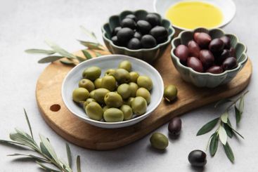 Variety of olives, olive oil, and olive branches served...