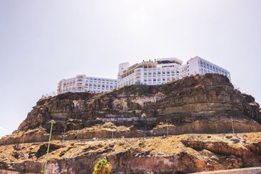 White modern hotel perched on steep rocky cliff 