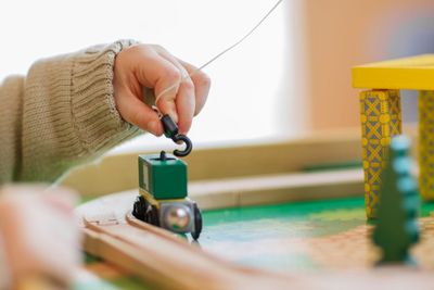 Little toddler boy playing with wooden toy, indoors